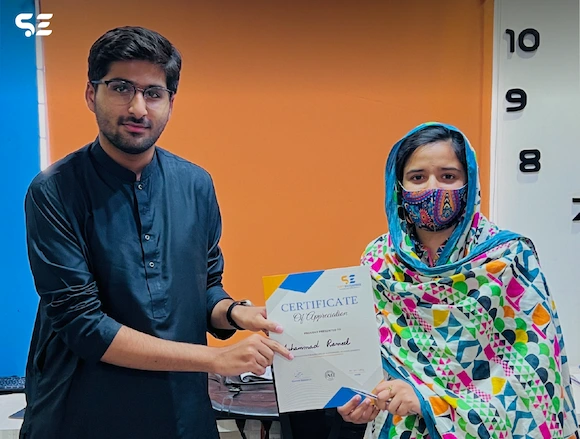 Soft Enterprise employee receiving a certificate from the company in recognition of achievements.