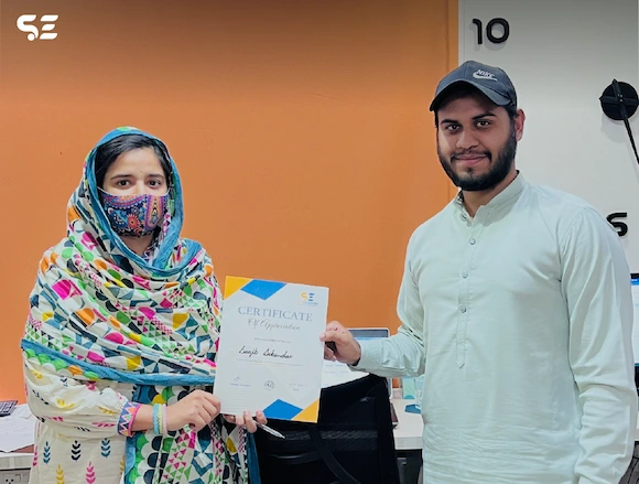 Soft Enterprise employee receiving a certificate from the company in recognition of achievements.