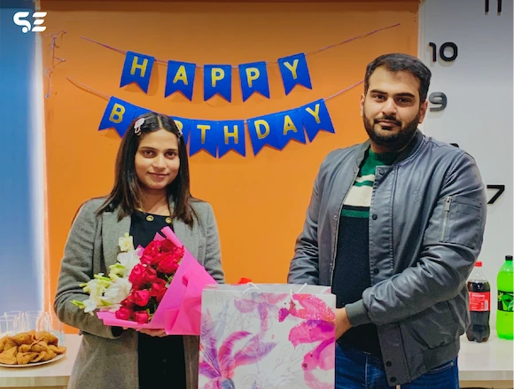 Team member celebrating birthday with a gift at Soft Enterprise Team Birthdays event in 2024.