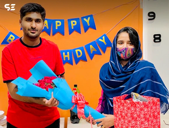 Team member celebrating birthday with a gift at Soft Enterprise Team Birthdays event in 2024.