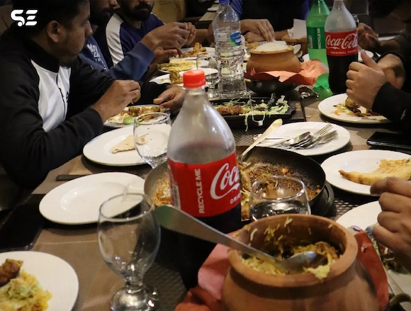 Close-up of the dinner table during Soft Enterprise's team dinner, with drinks, food, and plates visible.