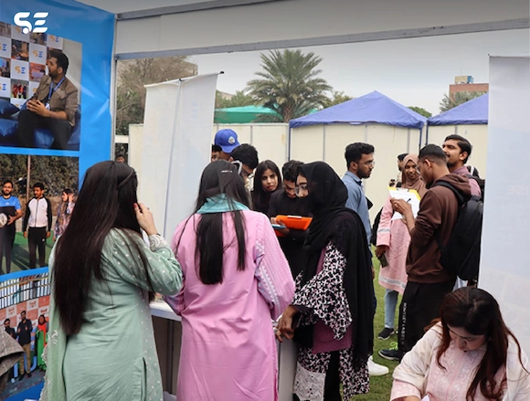 Soft Enterprise representatives discussing with visitors at UOL Career Fair 2025.