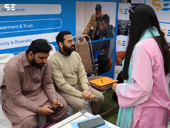 Team members assisting visitors at Soft Enterprise booth during UOL Career Fair 2025.