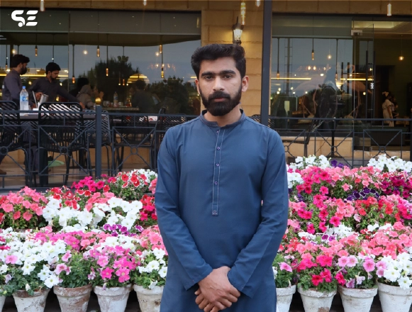 Soft Enterprise team member standing in front of flowers during the Annual Iftar event in March 2025