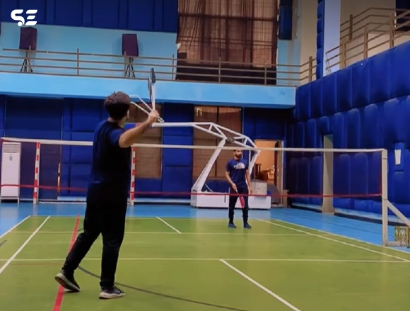 Soft Enterprise employees playing badminton during Smash Day event.