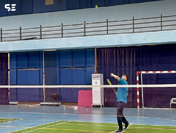 Soft Enterprise CEO playing badminton during Smash Day event.