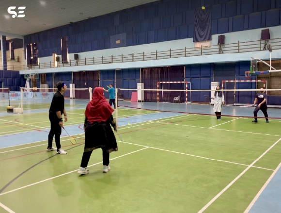 Soft Enterprise employees playing badminton during Smash Day event.