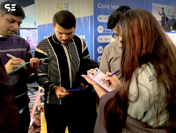 Attendees filling out forms at the Soft Enterprise event.