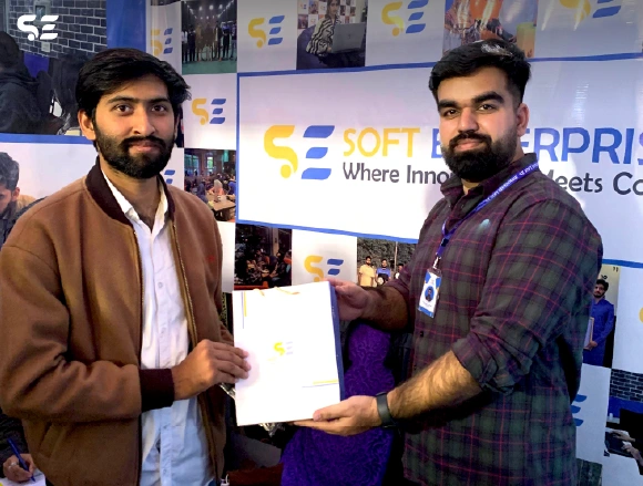 Soft Enterprise team member presenting gifts to participants during the event.