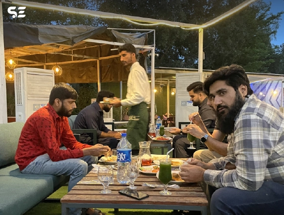 Group of employees seated at an outdoor dining setup