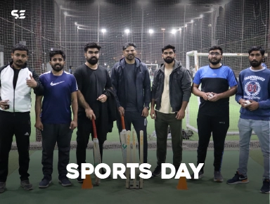 Team members posing on a sports field at night for Sports Day