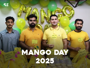Two male colleagues posing with yellow balloons for Mango Day 2025