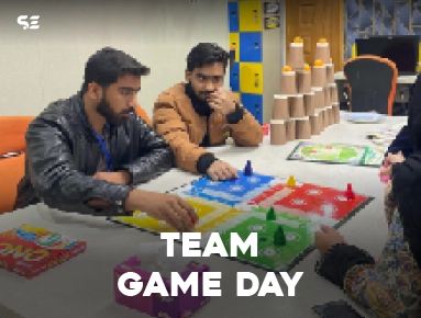 Team members playing a board game together during Team Game Day