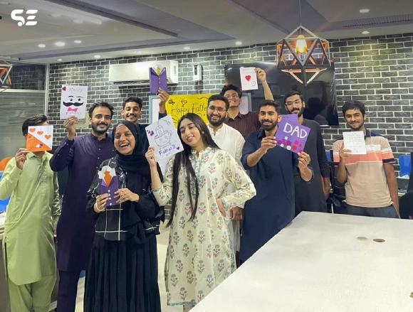 Female colleagues posing together holding handmade craft items