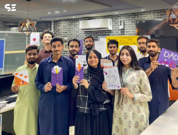 Group of employees holding colorful craft cards together