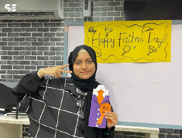 Female employee pointing at a handmade yellow craft sign