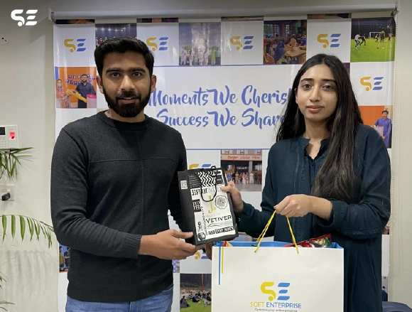 Two colleagues holding a gift bag at office celebration