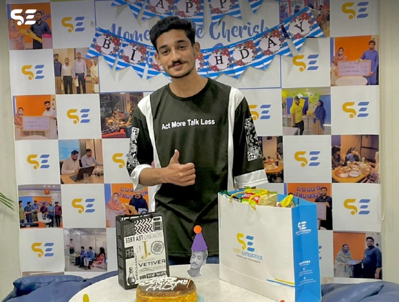 Employee posing solo while holding a gift bag at office event