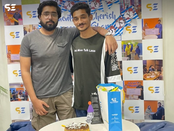 Two male employees posing together at a team celebration