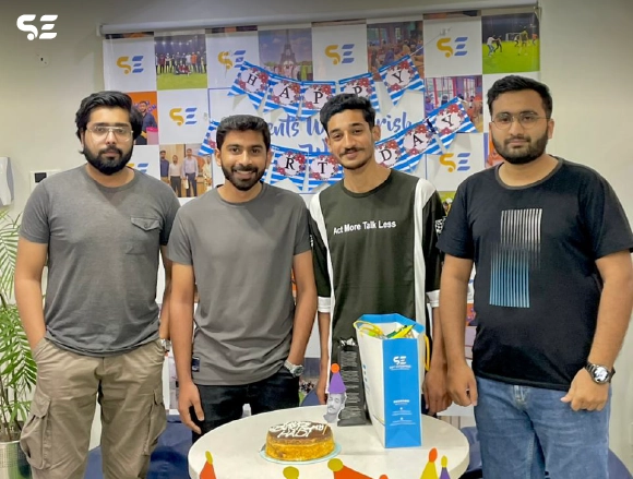 Casual group photo of Soft Enterprise team members at office event