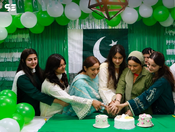 Female colleagues cutting cakes together at Independence Day celebration