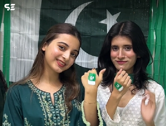 Two female employees posing with green ribbon bracelets