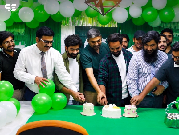 Group of male employees cutting cake together at Independence Day event