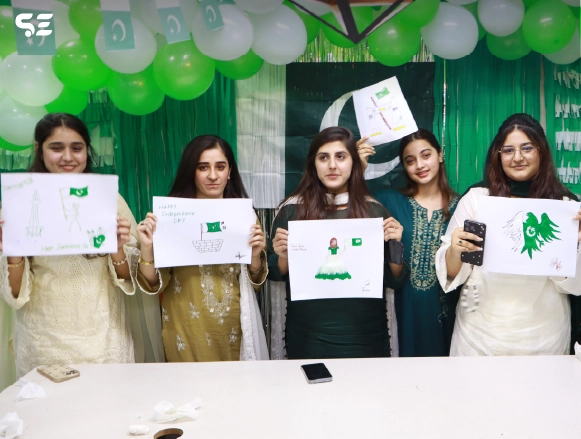 Female employee holding up a decorated card near green independence day decor