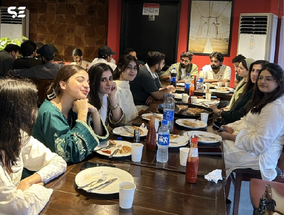 Employees seated together around a table enjoying a meal