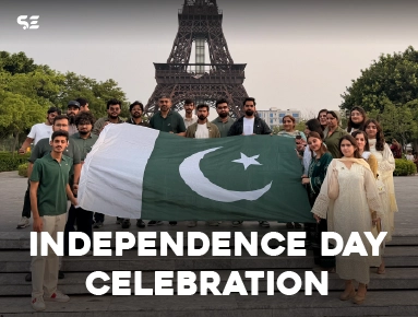 Team members holding a large Pakistani flag for Independence Day Celebration