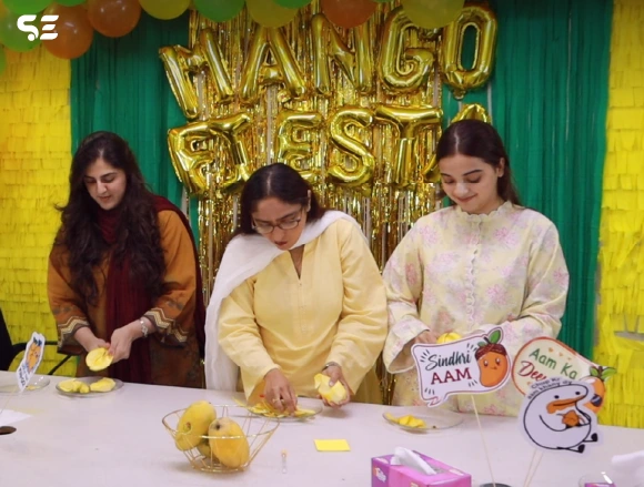 Female colleagues decorating a table with mango festival props