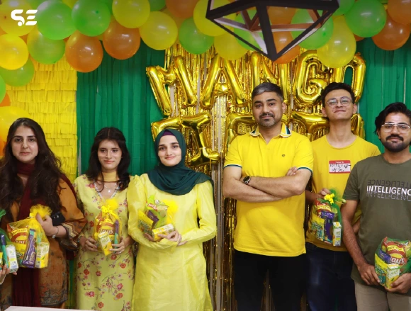 Group of colleagues posing together in yellow attire at Mango Fiesta