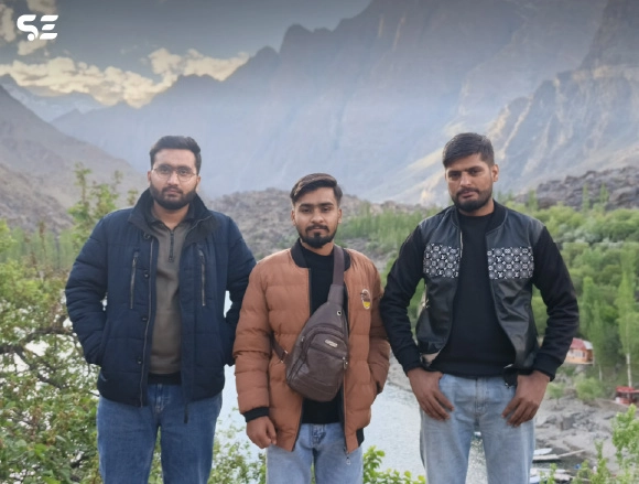 Two male employees standing together with mountain backdrop