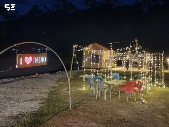 Illuminated outdoor camping setup with fairy lights at night