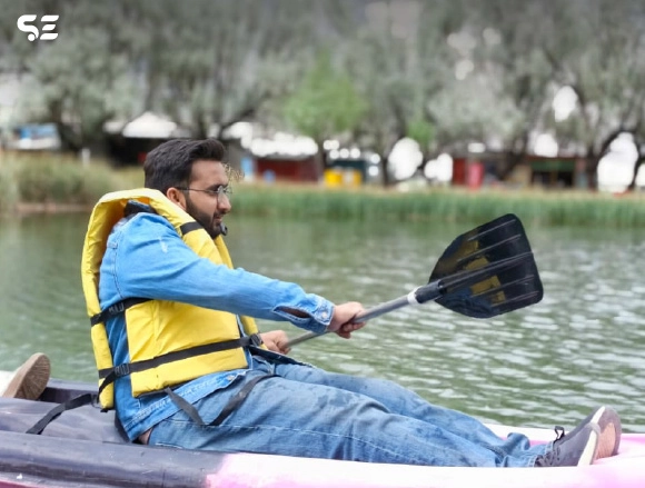 Man in orange life jacket kayaking on a lake