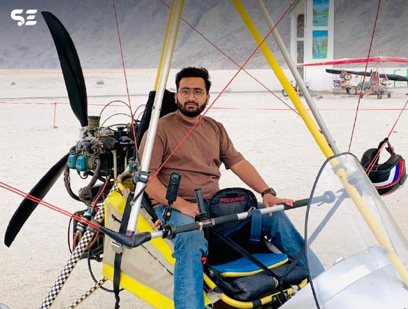 Man piloting a motorized paraglider on a runway
