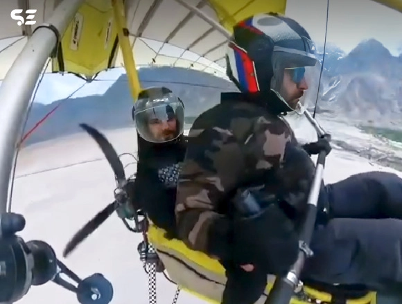 Two men on a hang glider preparing for takeoff