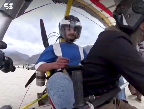 Two men preparing for a paragliding flight in the mountains