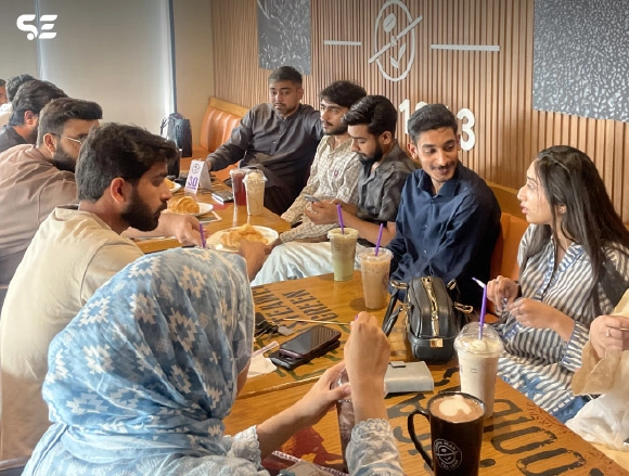 Colleagues gathered around a table enjoying food together