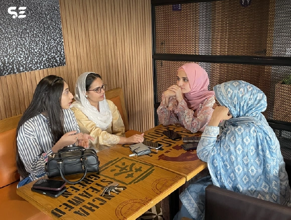Female colleagues chatting together at a restaurant table