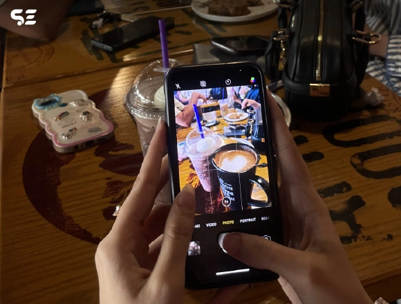 Close-up of hand taking a photo of food on a smartphone