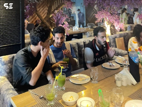 Two male colleagues laughing together during dinner