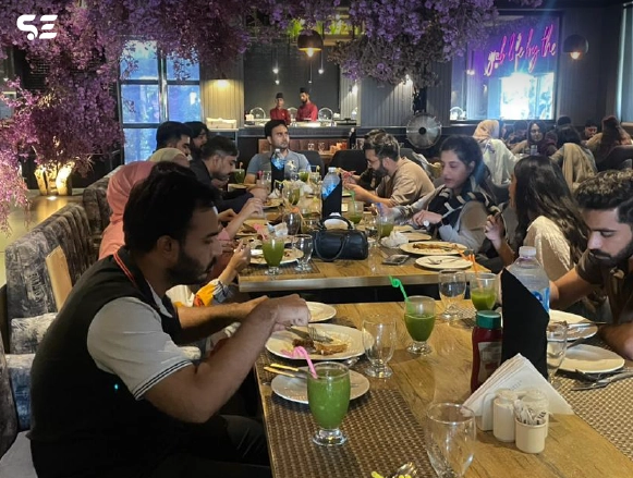 Team members enjoying a meal together at a long restaurant table