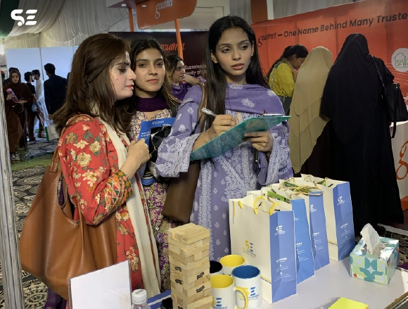 Female employees exchanging gift bags at an event