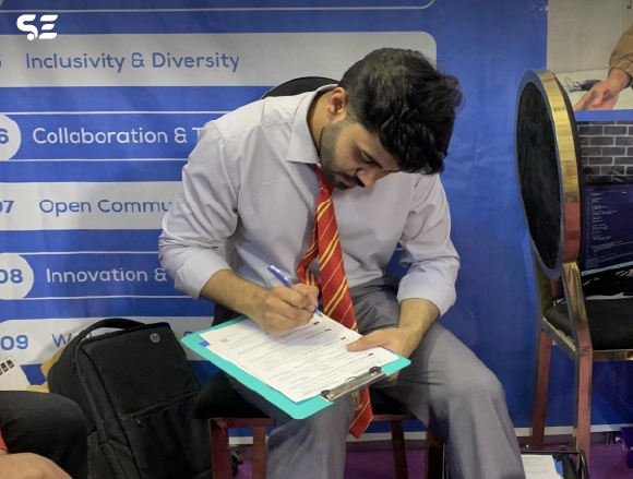 Male employee signing a document at an exhibition booth