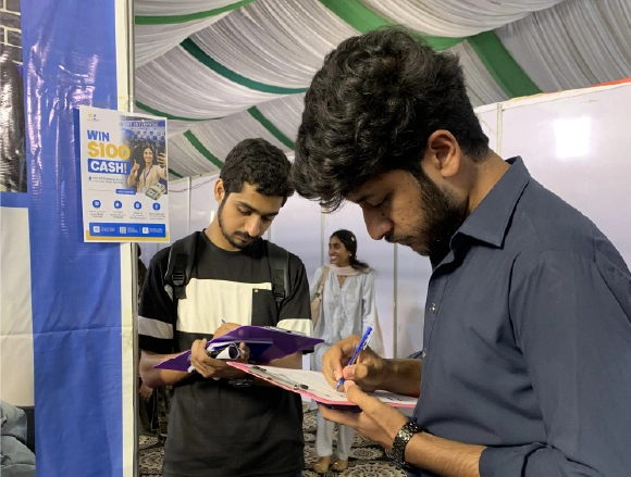 Male employee writing while a colleague looks over papers