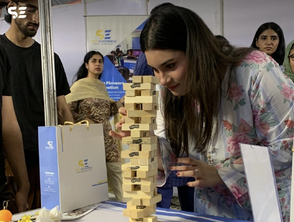 Team members building a Jenga tower together at event